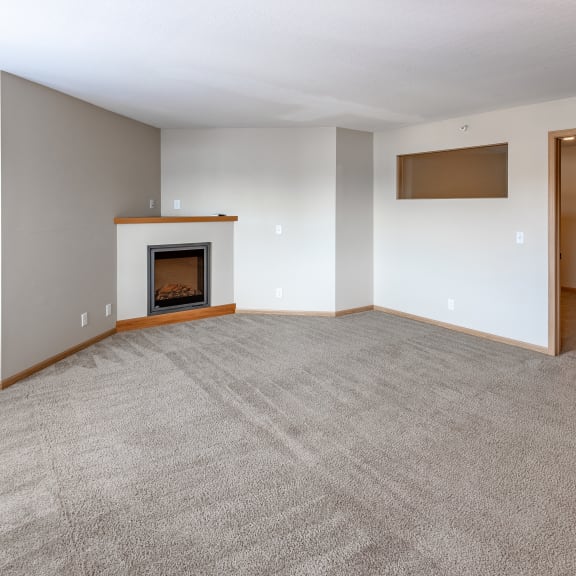 a living room with a fireplace and a carpeted floor