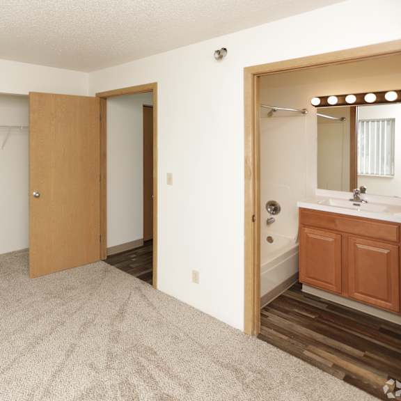 a room with a carpeted floor and a wooden door.