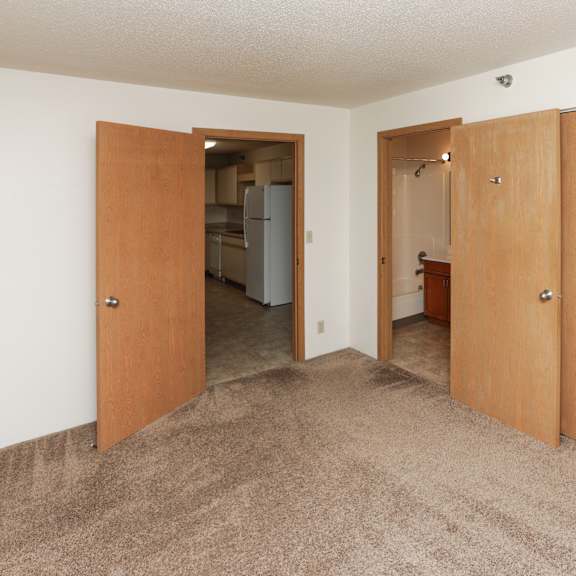 a room with a carpeted floor and wooden doors.