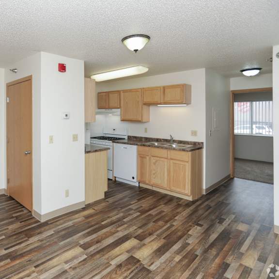 a kitchen with wooden floors and white walls.