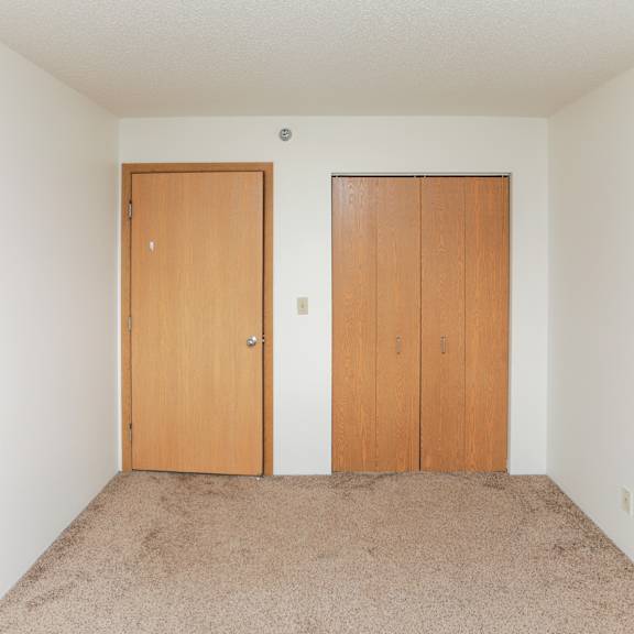 a room with two doors and carpeted floor.