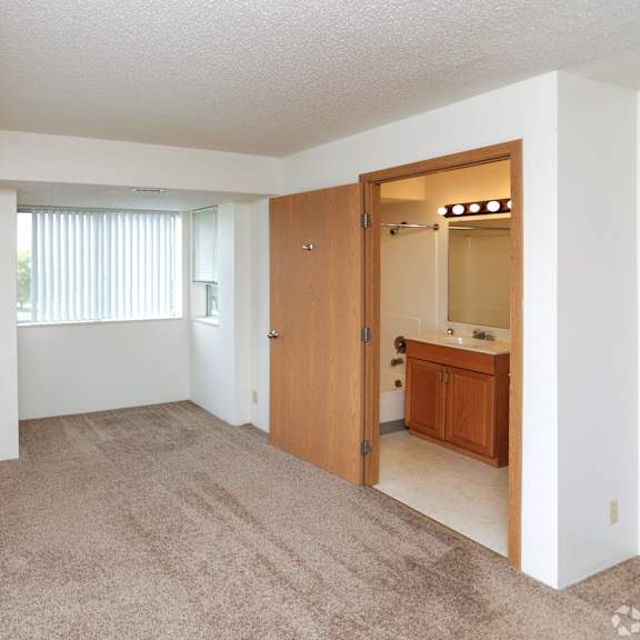 a room with a carpeted floor and a wooden door.