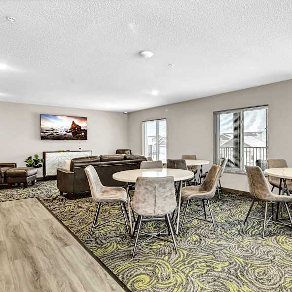 a community room with tables and chairs and a couch