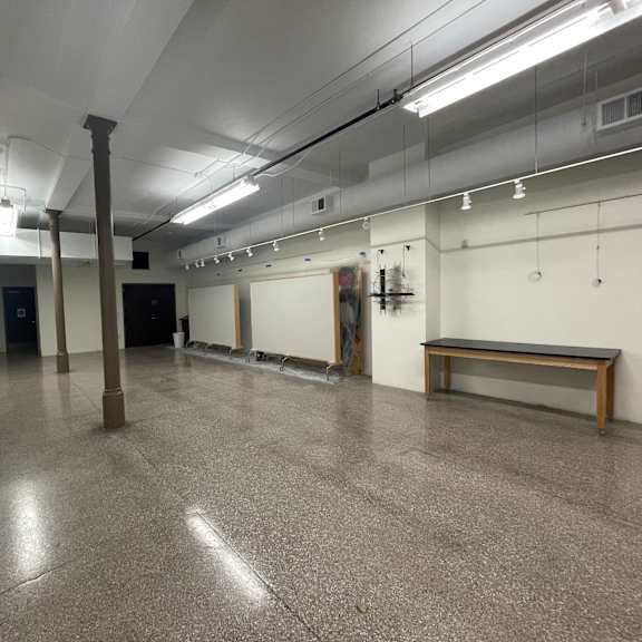a long hallway with a bench and a door at the end.