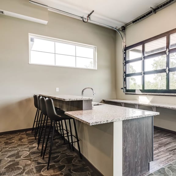 community room with a bar height counter top and seating plus a window