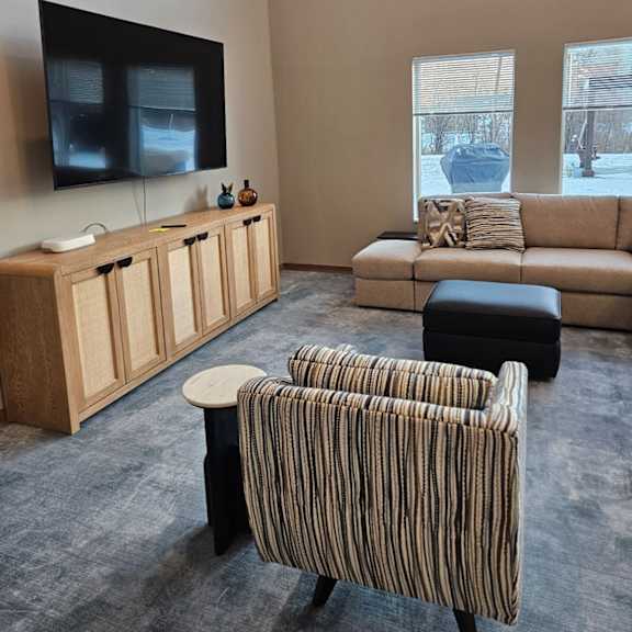 a living room with a striped chair and a couch.