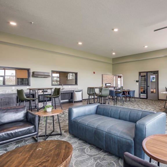 community room with a couch and tables and a kitchen