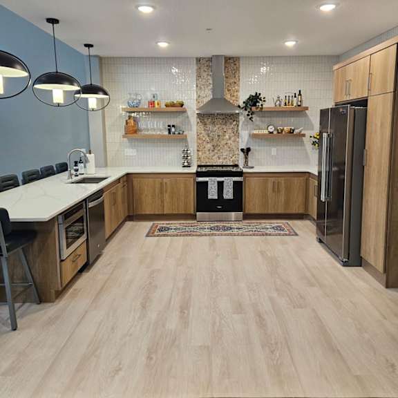 a modern kitchen with wooden floors and a central island.