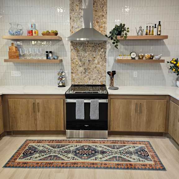 a kitchen with a patterned rug on the floor.