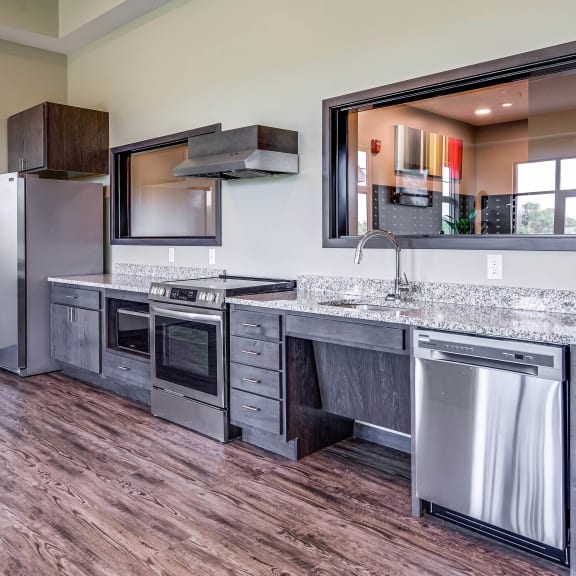 community room  kitchen with stainless steel appliances and a counter top