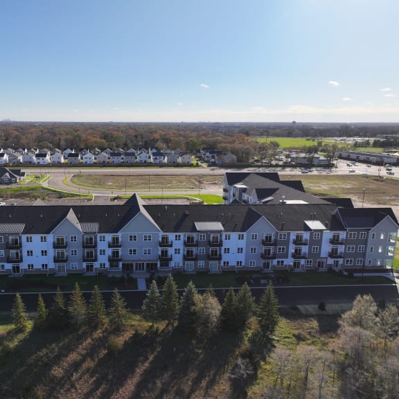 an aerial view of an apartment complex with a field in the background