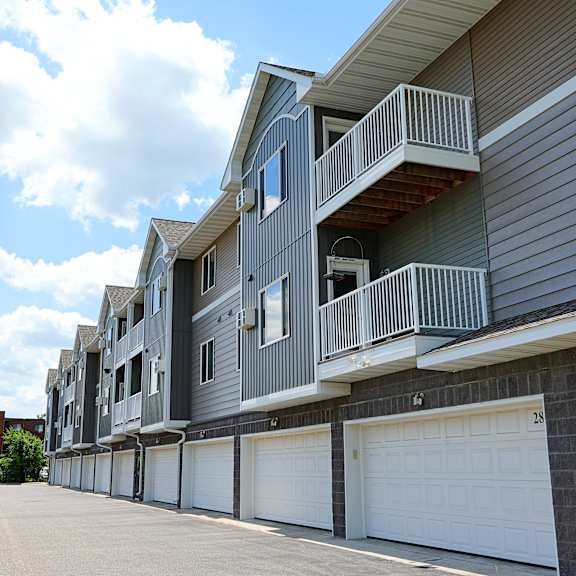 apartment building with garage doors and balconies.