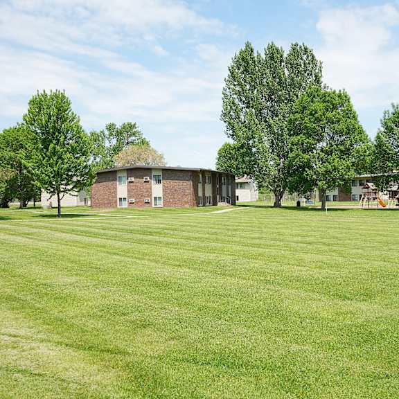 a grassy field with a building in the background.