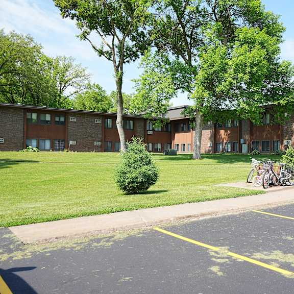 a parking lot in front of a building with a bicycle parked.