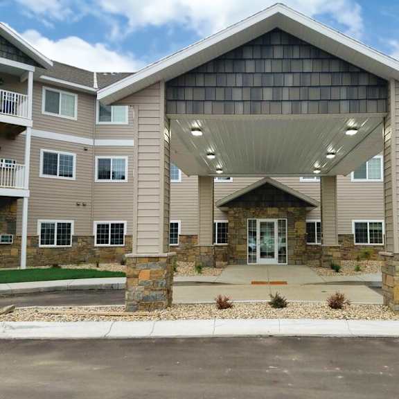 a large, modern building with a glass entrance and stone pillars.
