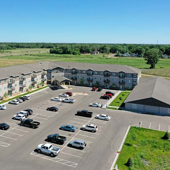 a parking lot with cars and a building in the background.