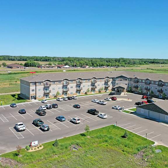 a parking lot with cars and a building in the background.