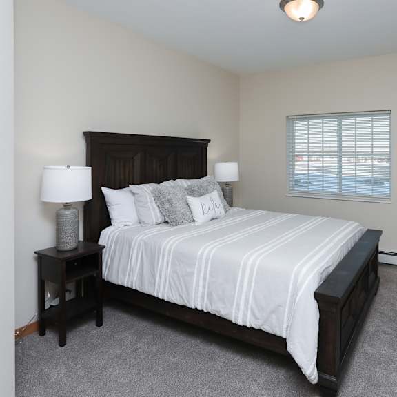 a bedroom with a large bed and two lamps.