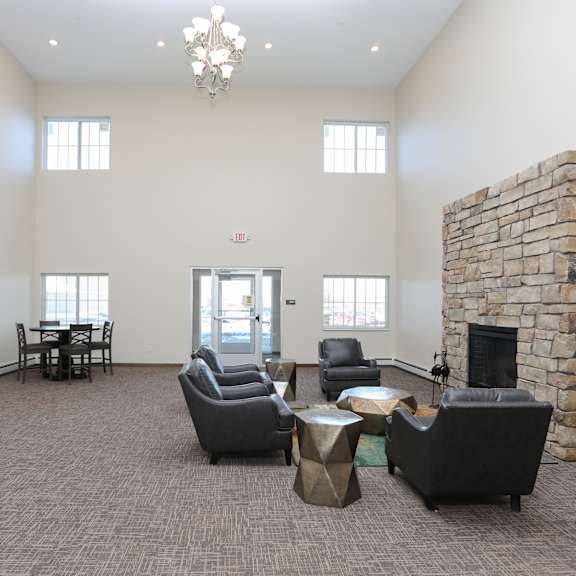 a living room with a stone fireplace and a chandelier.