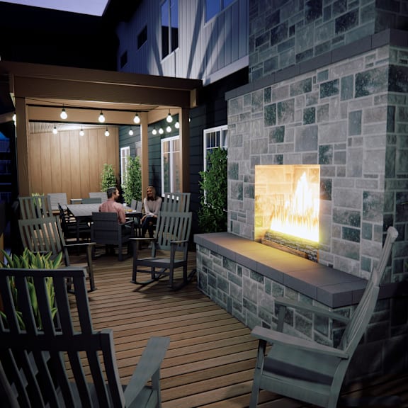 a couple is sitting in a backyard with a fireplace.