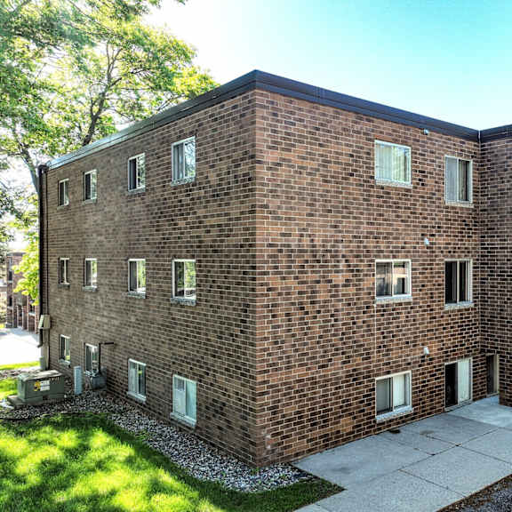 a brick building with a parking lot in front.