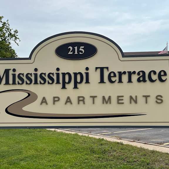 a sign for mississippi terrace apartments is displayed in front of a building.