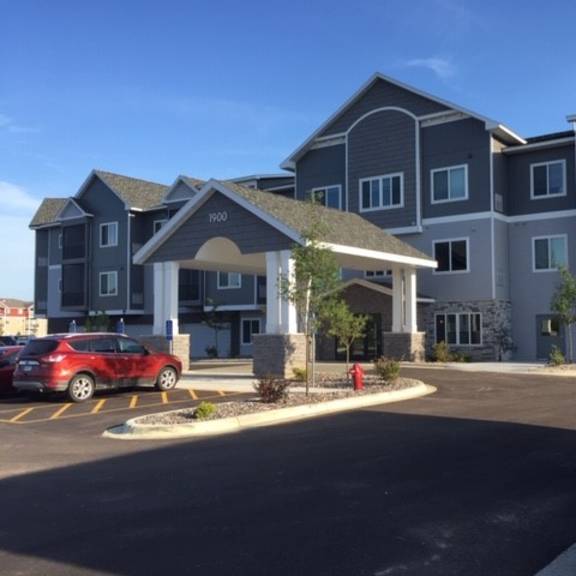 an apartment building with a red car parked in front of it
