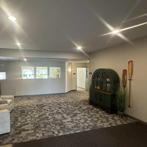 a spacious room with a grey carpet and a mirror on the wall.