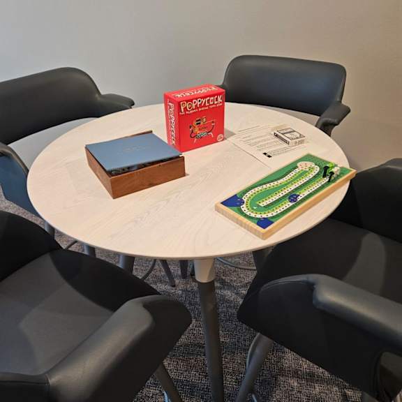 a round table with a book and a box on it surrounded by chairs.