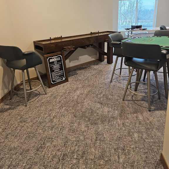 a room with a carpeted floor and a pool table.