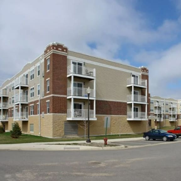 an apartment building with cars parked in front of it