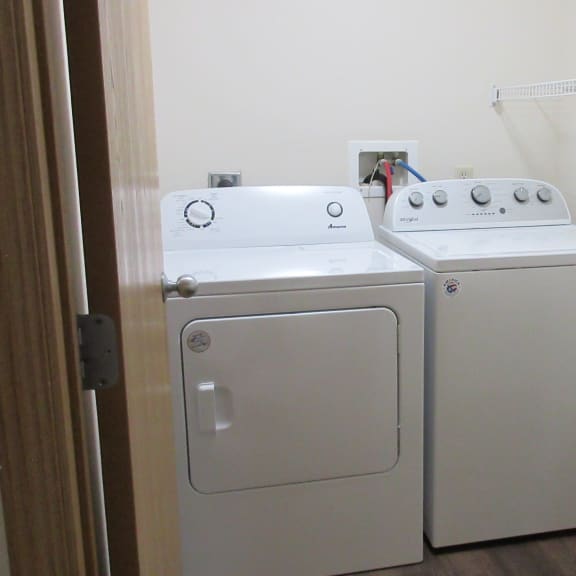 a white washer and dryer in a white room with a door