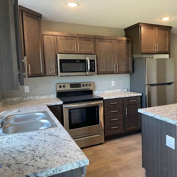 a kitchen with granite counter tops and stainless steel appliances