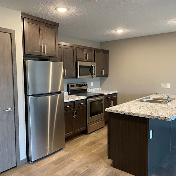 a kitchen with stainless steel appliances and a marble counter top