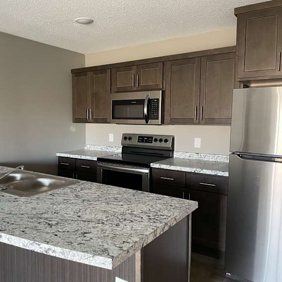 a kitchen with granite counter tops and stainless steel appliances