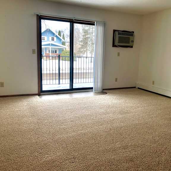 a room with a carpeted floor and a sliding glass door.