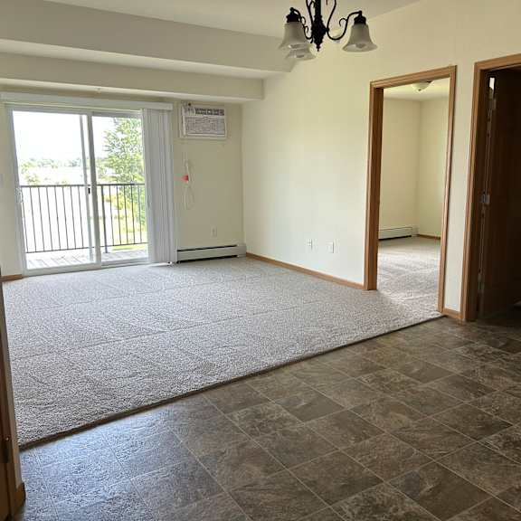 a room with a sliding glass door and a tiled floor.