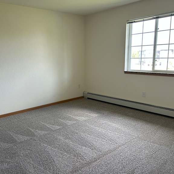 a room with a carpeted floor and a window.