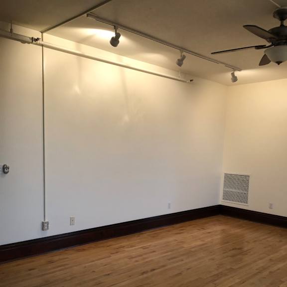 a white wall with a ceiling fan and a light on it.