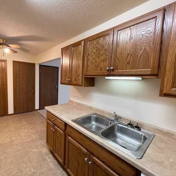a kitchen with brown cabinets and a tile floor.