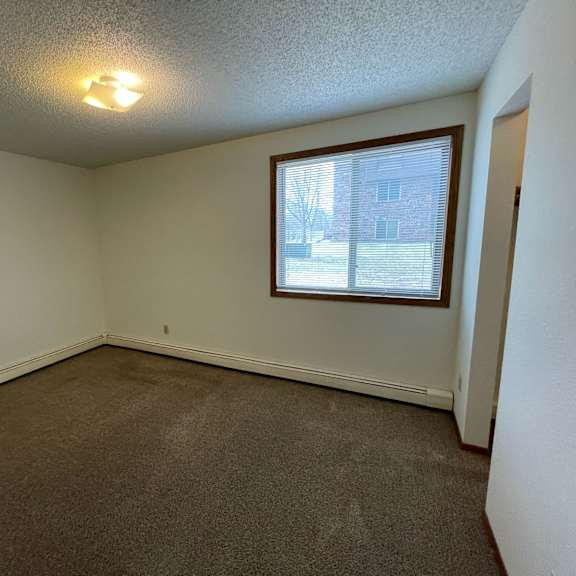 a room with a window and carpeted floor.