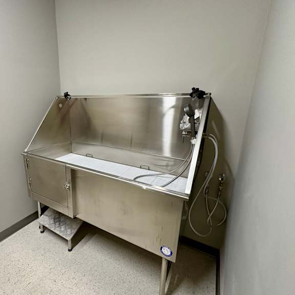a stainless steel sink in a room with white walls.
