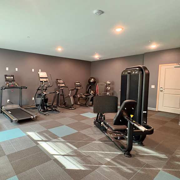 a gym with treadmills, exercise bikes, and other equipment.
