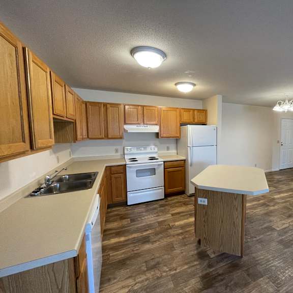 a kitchen with wooden cabinets and a white refrigerator.