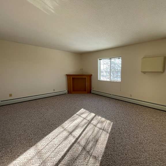 a room with a carpeted floor and a wooden door.