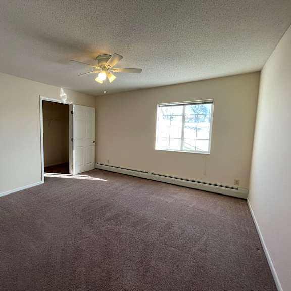 a room with a ceiling fan and a window.