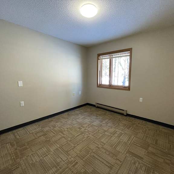 a room with a window and a wooden floor.