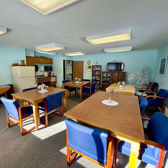 a dining room with blue chairs and wooden tables.