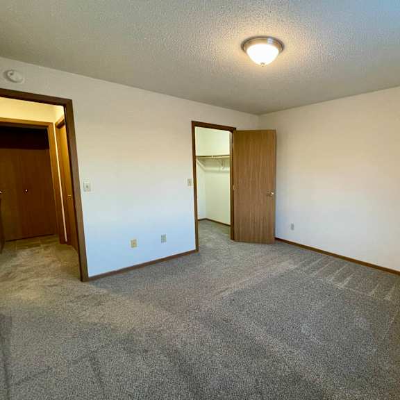 a room with a carpeted floor and two doors.