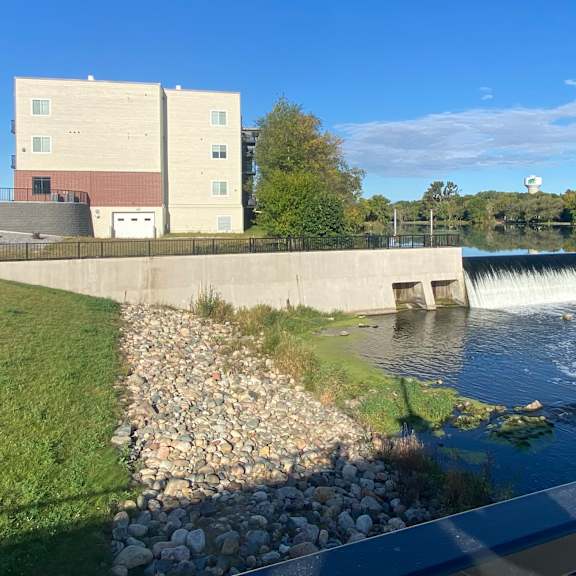 a waterfall in a river with a building in the background
